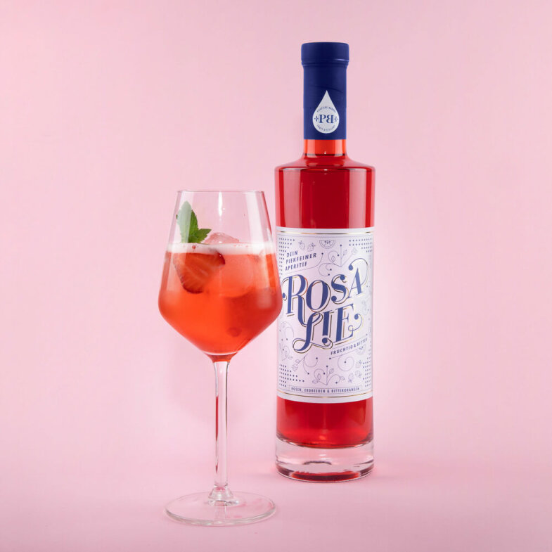 Moddbild mir Rosalie 700 ml und Weinglas vor rosa...