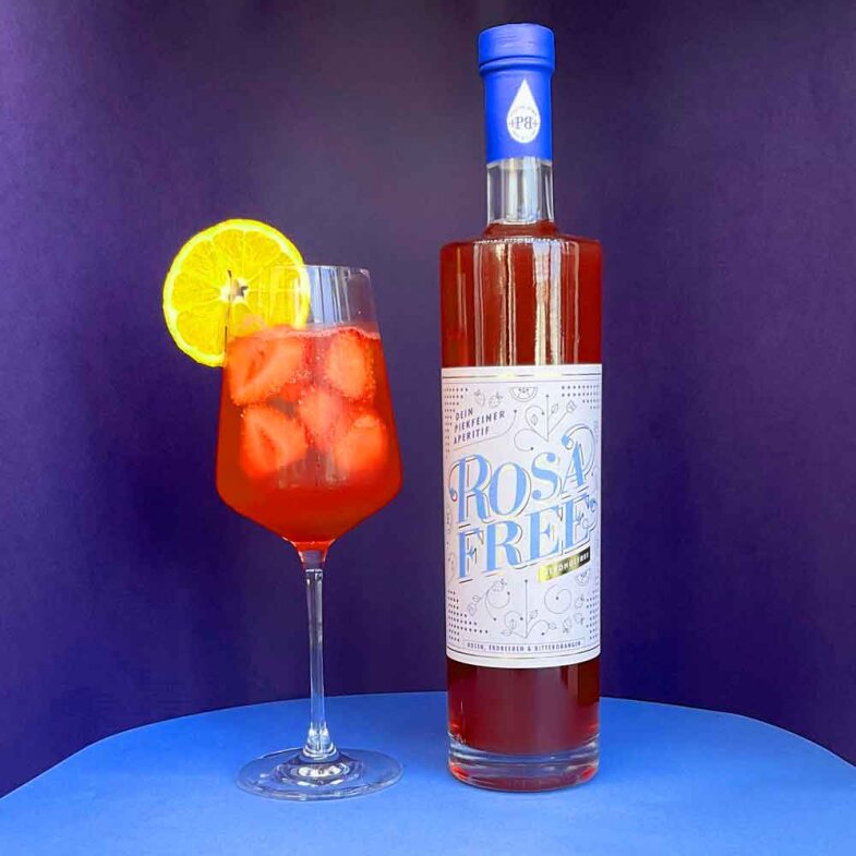 Moodbild Rosafee 700 ml mit Weinglas vor blauem Hintergrund